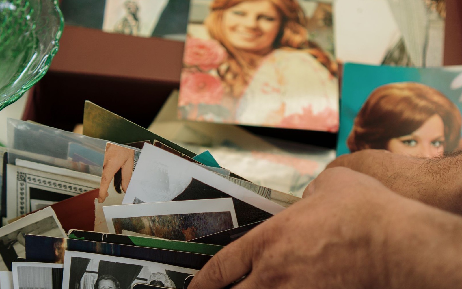 Hands sorting a personal archive of family photographs